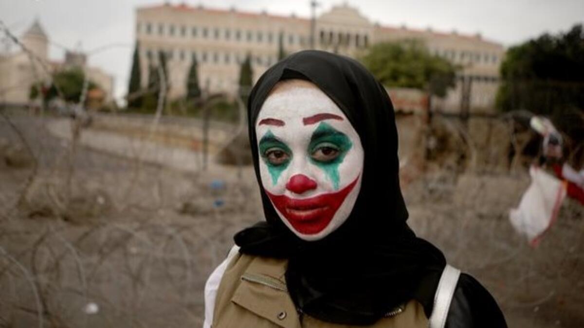 A Lebanese woman with her face painted with the character of the Joker takes part in a protest in downtown Beirut on October 23, 2019 as demonstrations to demand better living conditions and the ouster of a cast of politicians who have monopolised power and influence for decades continue.  Patrick BAZ / AFP