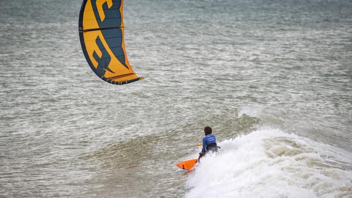 A picture taken on October 10, 2019, shows a kitesurfer riding waves at Dakhla beach in Morocco-administered Western Sahara. In the heart of disputed Western Sahara, a former garrison town has become an unlikely tourist magnet after kitesurfers discovered the windswept desert coast on the Atlantic is perfect for their sport. FADEL SENNA / AFP