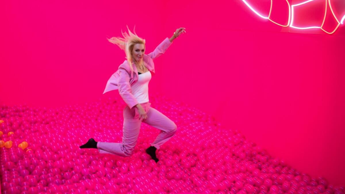 A woman jumps into a ball bath at the "Supercandy Pop-Up Museum Vol. 2" in Cologne, western Germany on November 1, 2019. It is an interactive museum and offers a photo backdrop for social media at 25 stations. INA FASSBENDER / AFP