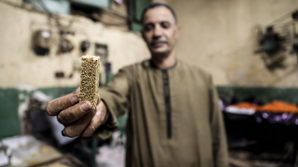 An Egyptian confectioner shows a sweet sesame bar at a candy factory in the capital Cairo on November 2, 2019, ahead of celebrations of the Muslim Prophet Mohammed's birthday, known as "Al Mawlid Al Nabawi". Prophet Mohamed was born in Saudi Arabia's arid mountainous city of Mecca, the holiest in Islam, some 1490 years ago. Sunni Muslims in many parts of the world celebrate his birthday on the 12th day of the third month of the Islamic calendar, which will fall this year on November 9th.  Mohamed el-Shahed