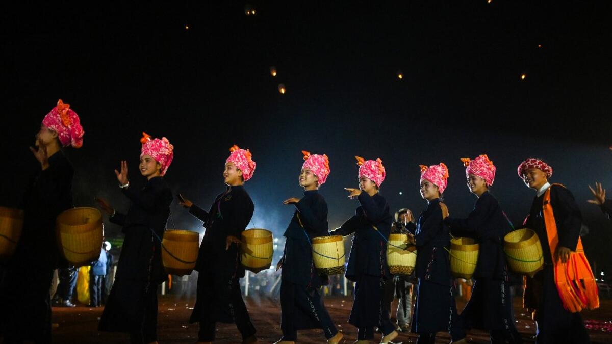 This picture taken on November 4, 2019 shows Pa-O ethnic women performing a traditional dance during the opening ceremony of the Tazaungdaing Lighting Festival at Taunggyi in Myanmar's northeastern Shan State. Brightly coloured balloons with hundreds of homemade fireworks woven into their frames are sent soaring into the night sky, showering down cascades of sparks onto adoring crowds in the annual Taunggyi fire balloon festival. Ye Aung THU / AFP