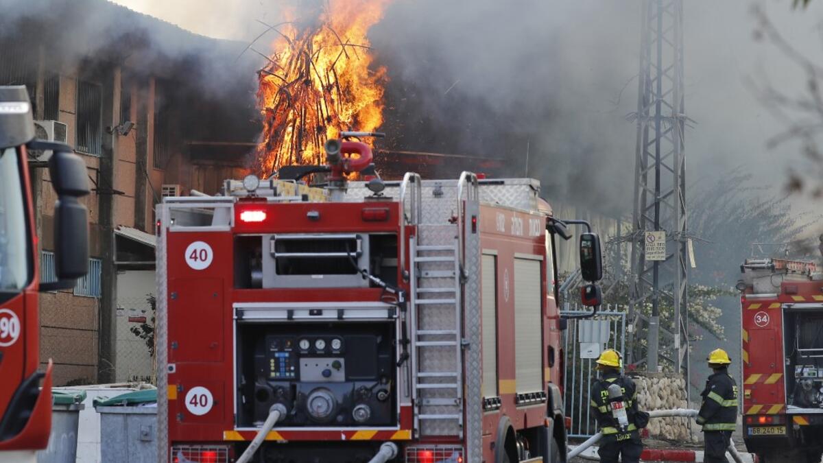 Israeli firefighter trucks douse a burning factory in the southern Israeli town of Sderot, after it was reportedly hit with rockets fired from the Gaza Strip on November 12, 2019. Israel's military killed a commander of Palestinian militant group Islamic Jihad in a strike on his home in Gaza early in the morning, prompting retaliatory barrages of rocket fire from the Gaza Strip towards Israel where residents ran to bomb shelters while air raid sirens rang out in various parts of the country. Ahmad GHARABLI