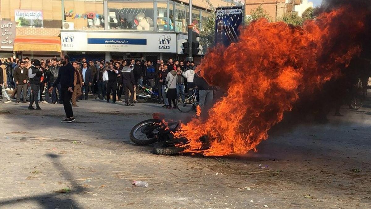 Iranian protesters gather around a burning motorcycle during a demonstration against an increase in gasoline prices in the central city of Isfahan, on November 16, 2019. AFP