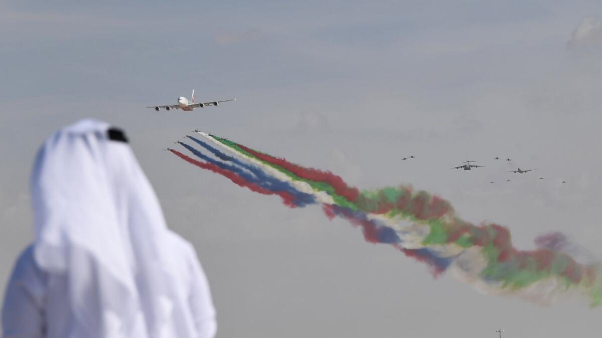 An emirati man watches the United Arab Emirates' air force Aerobatic Team, Al-Fursan, performing along with an Emirates Airline's Airbus A380 at the Dubai Airshow November 17, 2019. KARIM SAHIB / AFP
