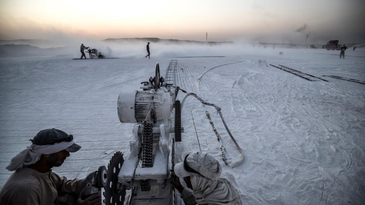 Labourers work at the "White Mountain" limestone extraction quarry site near Egypt's southern city of Minya, some 265 kilometres south of the capital, on November 13, 2019. Covered in fine white dust, labourers at the so-called "White Mountain" off Minya toil in shifts amidst brutal conditions with little workplace safety for paltry pay. They handle dangerous machinery with finesse, and shrug off the dangers of a job where a mistake can prove fatal. Khaled DESOUKI / AFP