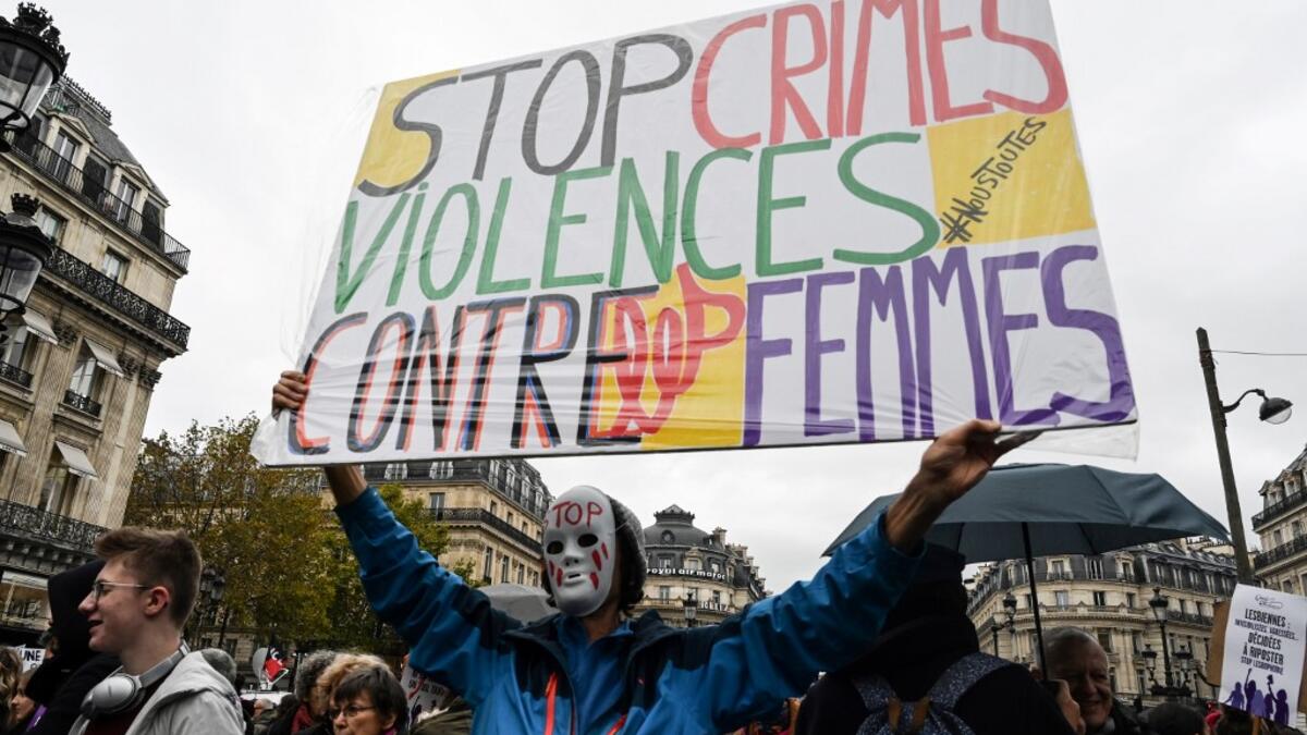 French activist Jean-Baptiste Redde, aka Voltuan, holds up a placard reading " Stop crimes against the women" as he takes part in a protest during the International day for elimination of violence against women in Paris, on November 23, 2019. DOMINIQUE FAGET / AFP