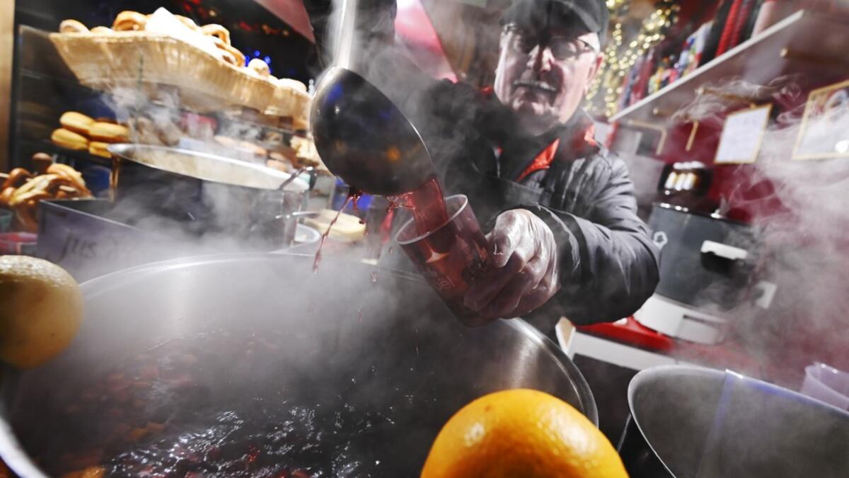 A stall tenant serves mulled wine at the traditional Christmas market in Strasbourg, eastern France, on November 23, 2019. FREDERICK FLORIN / AFP