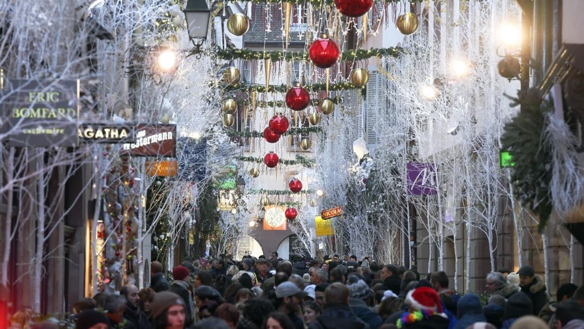 People walk under Christmas decorations during the traditional Christmas market in Strasbourg, eastern France, on November 23, 2019. FREDERICK FLORIN / AFP