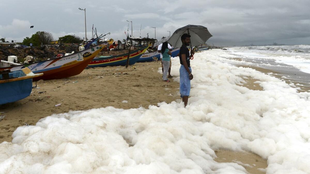 Residents play over foamy discharge, caused by pollutants, as it mixes with the surf at Marina beach in Chennai on December 1, 2019. Arun SANKAR / AFP