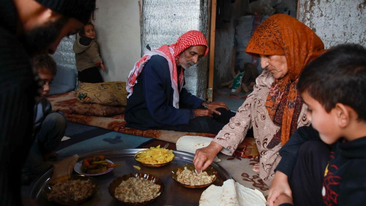 Umm Khaled and her family share a meal in a camp in a town called Haarem in the northwestern province of Idlib on November 29, 2019. Aaref WATAD / AFP