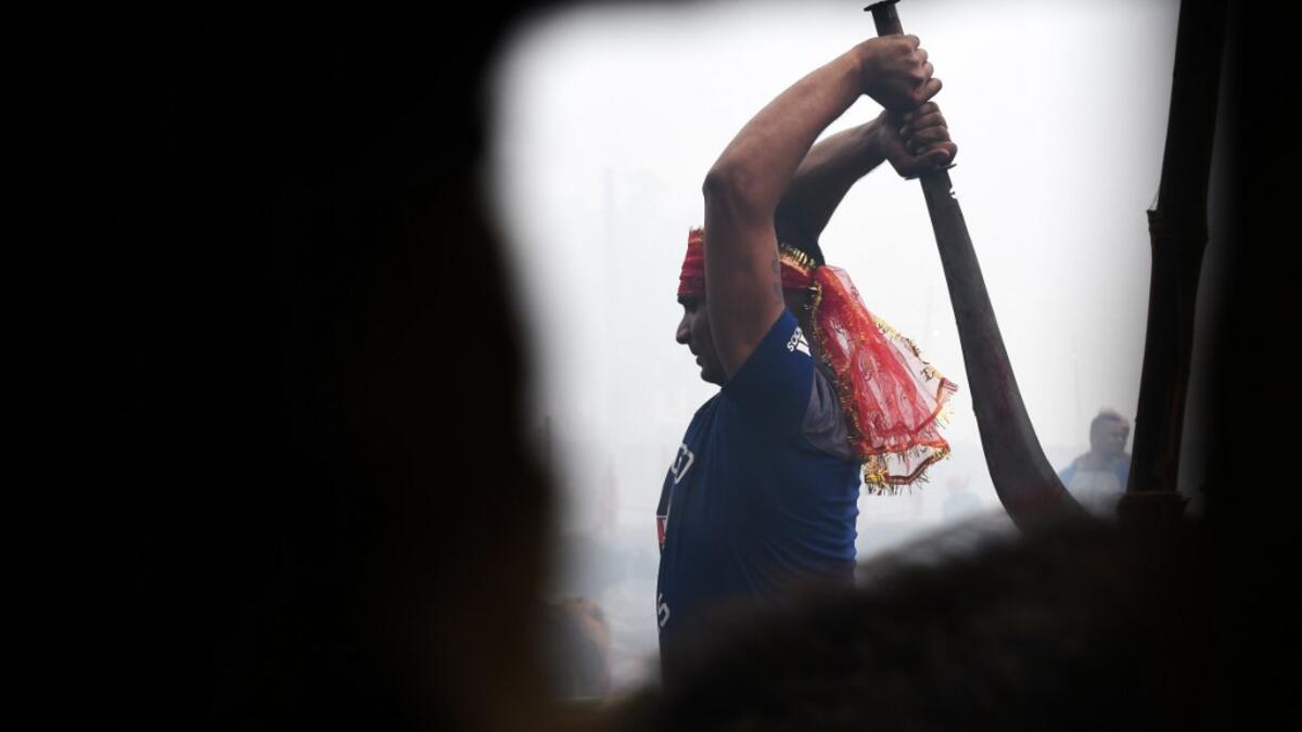 A Hindu devotee slaughters a buffalos as a offering during the Gadhimai Festival in Bariyarpur on December 3, 2019. Thousands of Hindu devotees gathered in southern Nepal for a festival believed to be the world's biggest ritual animal slaughter, despite court orders and calls by animal activists to end the event. The sacrifices take place every five years in Bariyarpur village close to the Indian border, in honour of the Hindu goddess of power. Prakash MATHEMA / AFP