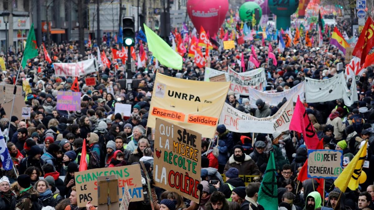 People take part in a demonstration against the pension overhauls, in Paris, on December 5, 2019 as part of a nationwide strike. Trains cancelled, schools closed: France scrambled to make contingency plans on for a huge strike against pension overhauls that poses one of the biggest challenges yet to French President's sweeping reform drive. Thomas SAMSON / AFP