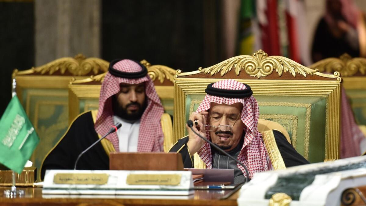 Saudi King Salman bin Abdulaziz (R), flanked by his son Crown Prince Mohammed bin Salman (L), puts on his spectacles as he prepares to read a document while chairing a session of the 40th Gulf Cooperation Council (GCC) summit held at the Saudi capital Riyadh on December 10, 2019. Fayez Nureldine / AFP