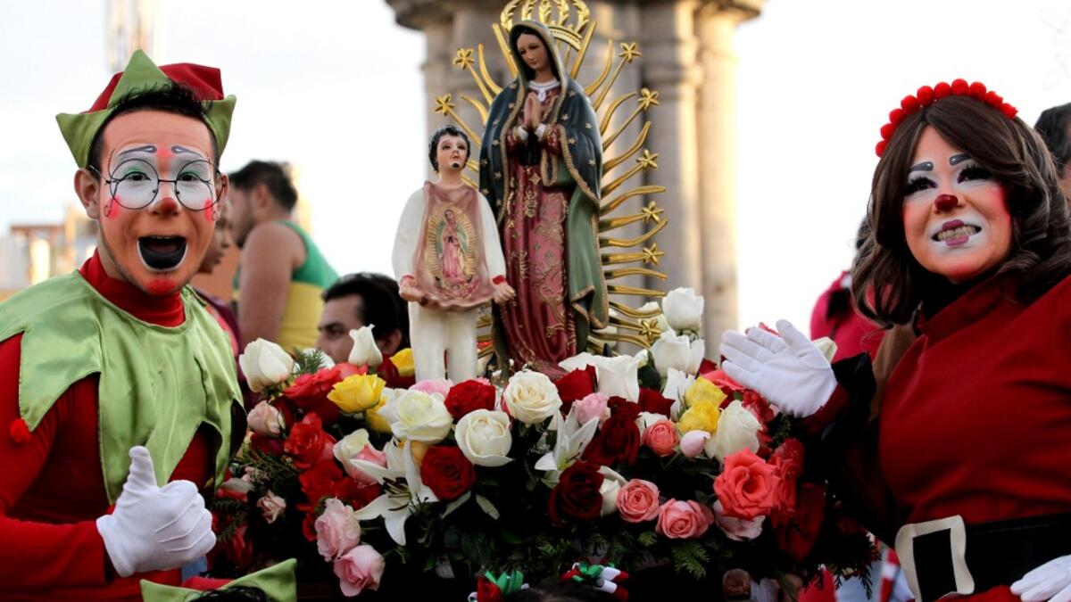 Clowns pose for a photograph with the Virgin of Guadalupe during the International Clown Day in Guadalajara, Mexico, on December 10, 2019. Ulises Ruiz / AFP