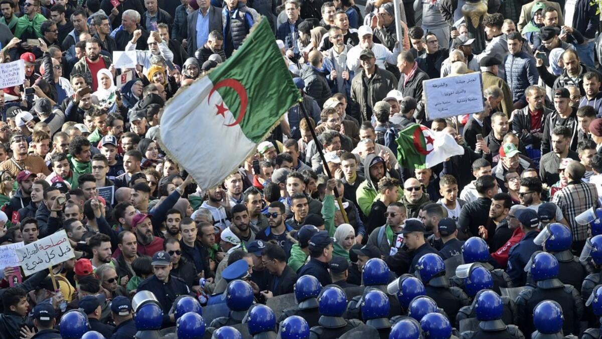 Algerian security surround protesters during an anti-government demonstration in the capital Algiers on December 11, 2019, ahead of the presidential vote scheduled for December 12. Algeria's contentious presidential election campaign is highlighting the vast gap between youth at the heart of a reformist protest movement and an ageing elite they see as clinging to power. RYAD KRAMDI / AFP