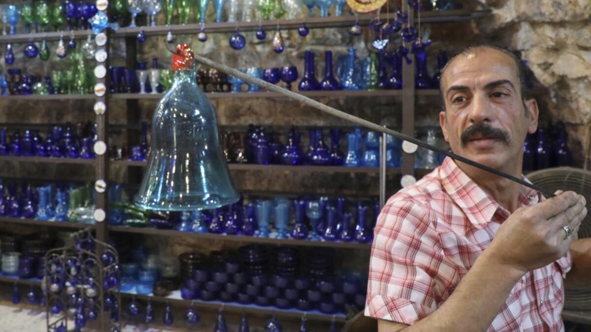 A Palestinian craftsman shapes molten glass into a Christmas ornament at his workshop in the southern West Bank city of Hebron, on December 15, 2019. HAZEM BADER / AFP