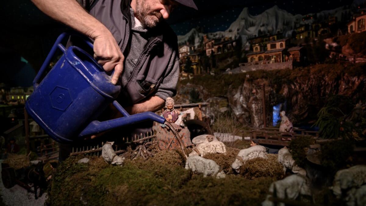 Volunteer Mario Curcetti uses a watering can to set a small river at the 43rd edition of the "Presepio of Cavallermaggiore", a 300sqm Christmas Nativity crib in the Oratorio San Michele on December 20, 2019 in Cavallermaggiore, near Cuneo, Northwestern Italy. The "Presepio" is made by ten volunteers who every year spend 3 months to build a new edition with hundreds of figures. MARCO BERTORELLO / AFP