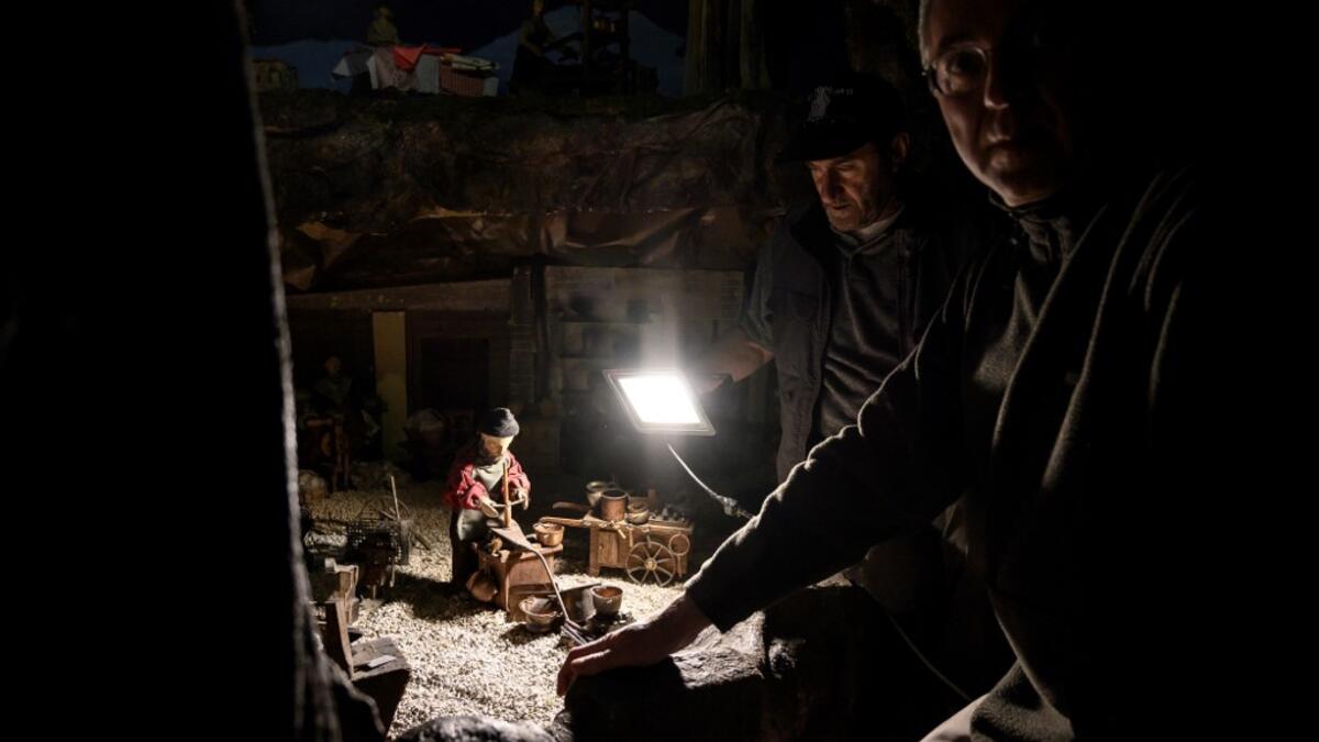 Volunteers Mario Curcetti and Dario Assie prepare figures for the "Presepio of Cavallermaggiore", a 300sqm Christmas Nativity crib in the Oratorio San Michele, are pictured at its 43rd edition on December 20, 2019 in Cavallermaggiore, near Cuneo, Northwestern Italy. The "Presepio" is made by ten volunteers who every year spend 3 months to build a new edition with hundreds of figures. MARCO BERTORELLO / AFP