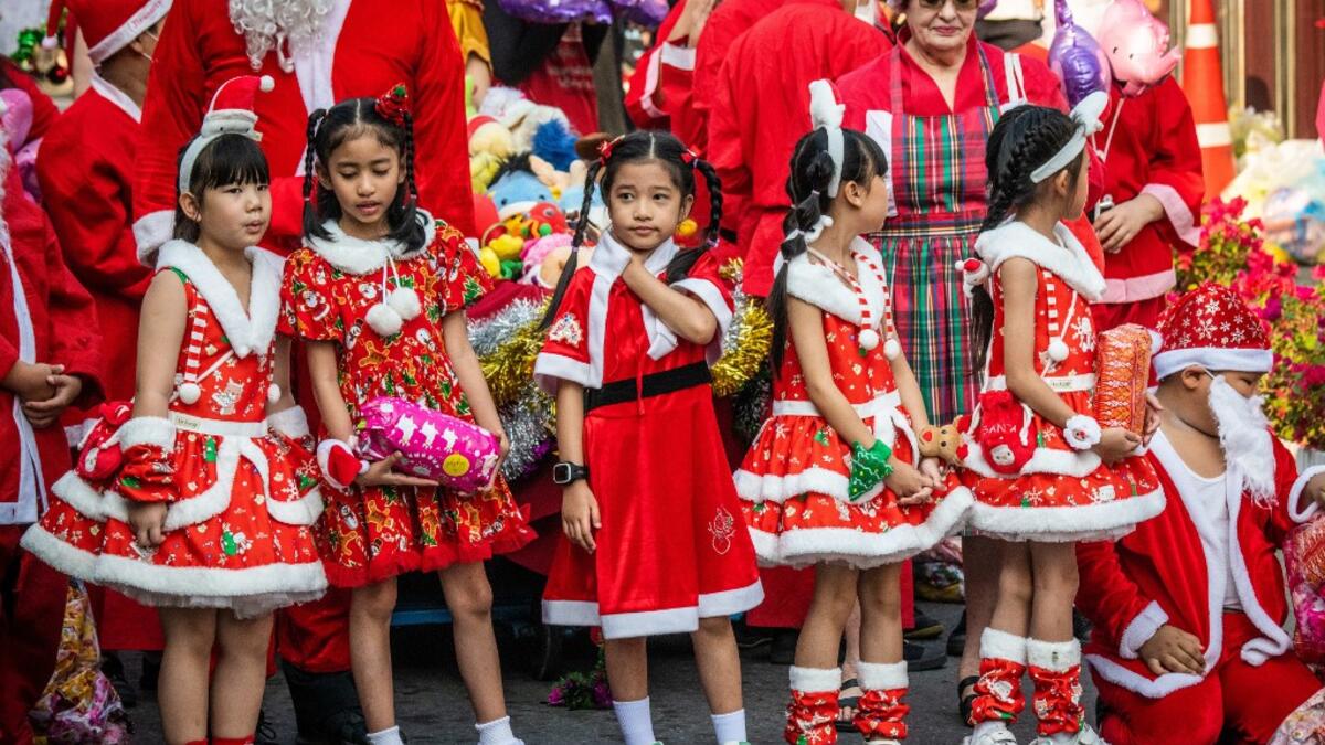 Children in Christmas costumes wait to receive gifts from elephants dressed in Santa Claus costumes during Christmas celebrations in Ayutthaya on December 23, 2019. Wearing red and white hats and a string of bells, Thai elephants passed out Christmas gifts to hundreds of schoolchildren on Monday despite growing criticism over using the animals in performances. The annual festive event is organised by a nearby elephant park, whose mahouts or handlers started in the early morning dressing the animals. Thailan