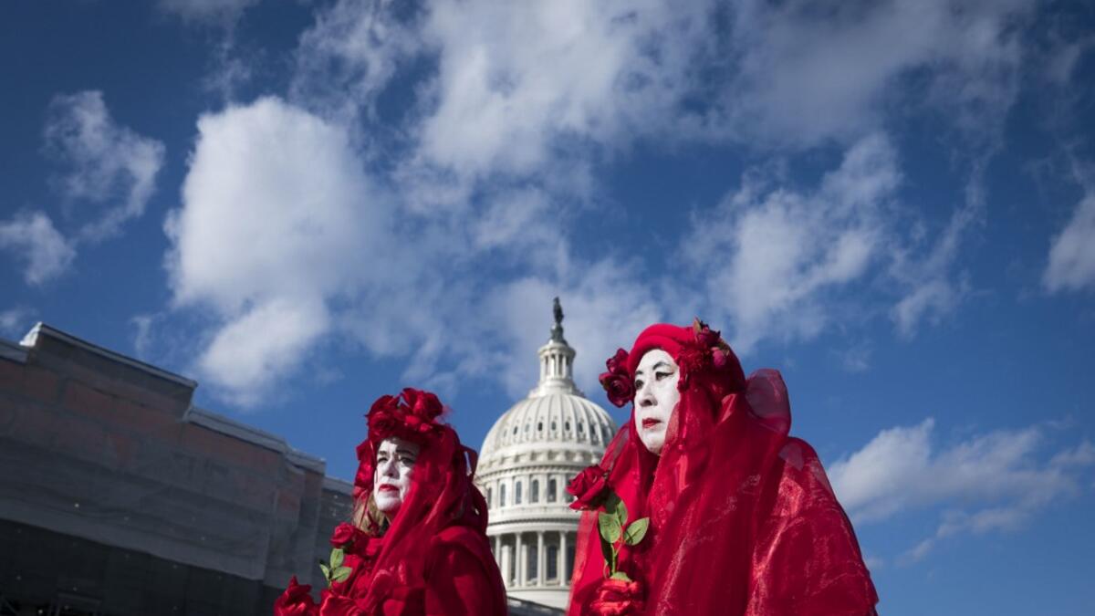 Climate change activists Kathy Beynette, left, and Natalie Pien, right, demonstrate outside of the U.S. Capitol on December 18, 2019 in Washington, DC. Today the U.S. House of Representatives will vote on two articles of Impeachment against U.S. President Donald Trump charging him with abuse of power and obstruction of Congress. Sarah Silbiger/Getty Images/AFP