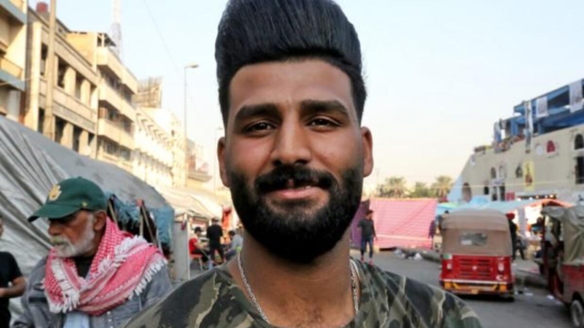 An Iraqi anti-government demonstrator sporting a pompadour hairstyle poses at Tahrir Square in central Baghdad on December 23, 2019. Since the start of Iraq's anti-government protests on October 1, one thing strikes the eye perhaps above all else -- the unbridled hairstyles young men sport. High quiffs, tight fades and loads of attitude -- it is quite the male beauty pageant. SABAH ARAR / AFP