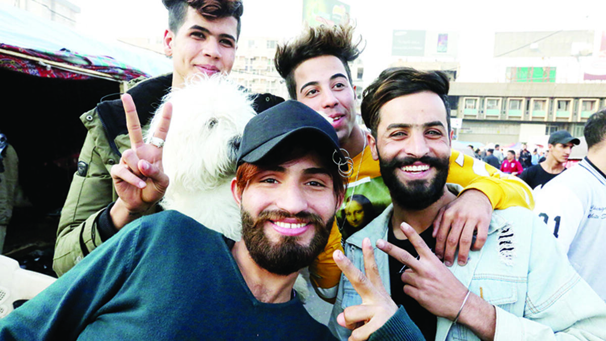 Iraqi anti-government demonstrators sporting a pompadour hairstyle pose at Tahrir Square in central Baghdad on December 23, 2019. Since the start of Iraq's anti-government protests on October 1, one thing strikes the eye perhaps above all else -- the unbridled hairstyles young men sport. High quiffs, tight fades and loads of attitude -- it is quite the male beauty pageant. SABAH ARAR / AFP