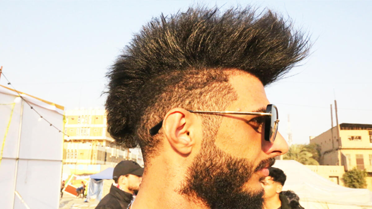 An Iraqi anti-government protestor poses with a mohawk hairstyle at Tahrir Square in central Baghdad on December 23, 2019. Since the start of Iraq's anti-government protests on October 1, one thing strikes the eye perhaps above all else -- the unbridled hairstyles young men sport. High quiffs, tight fades and loads of attitude -- it is quite the male beauty pageant. SABAH ARAR / AFP