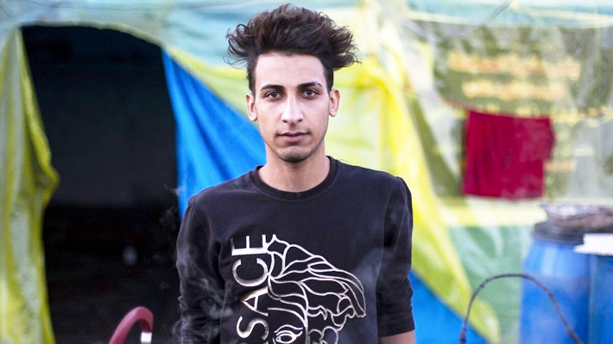 An Iraqi anti-government demonstrator sporting a pompadour hairstyle poses in the southern city of Basra on December 23, 2019. Since the start of Iraq's anti-government protests on October 1, one thing strikes the eye perhaps above all else -- the unbridled hairstyles young men sport. High quiffs, tight fades and loads of attitude -- it is quite the male beauty pageant. Hussein FALEH / AFP