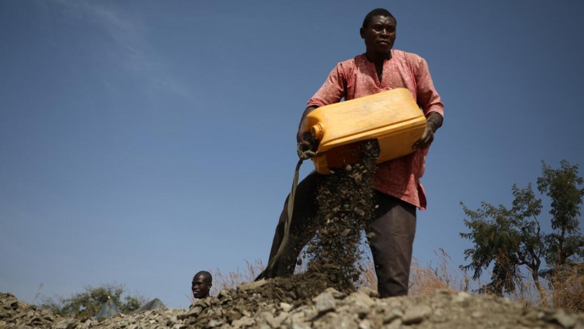 A miner dumps rocks out of a platic container in Anka near Gusau, on December 4,2019. For generations, the mineral-rich earth of Nigeria's Zamfara state has provided families living here with a way to make ends meet. Kola Sulaimon / AFP