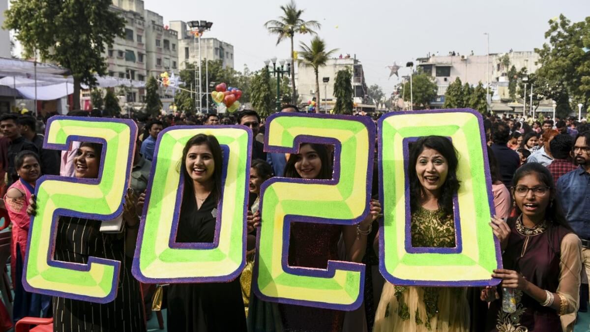 Christians react as they pose holding '2020' numericals signs on the occasion of the New Year celebrations at the Methodist Church Maninagar in Ahmedabad marking New Year, on January 1, 2020. SAM PANTHAKY / AFP