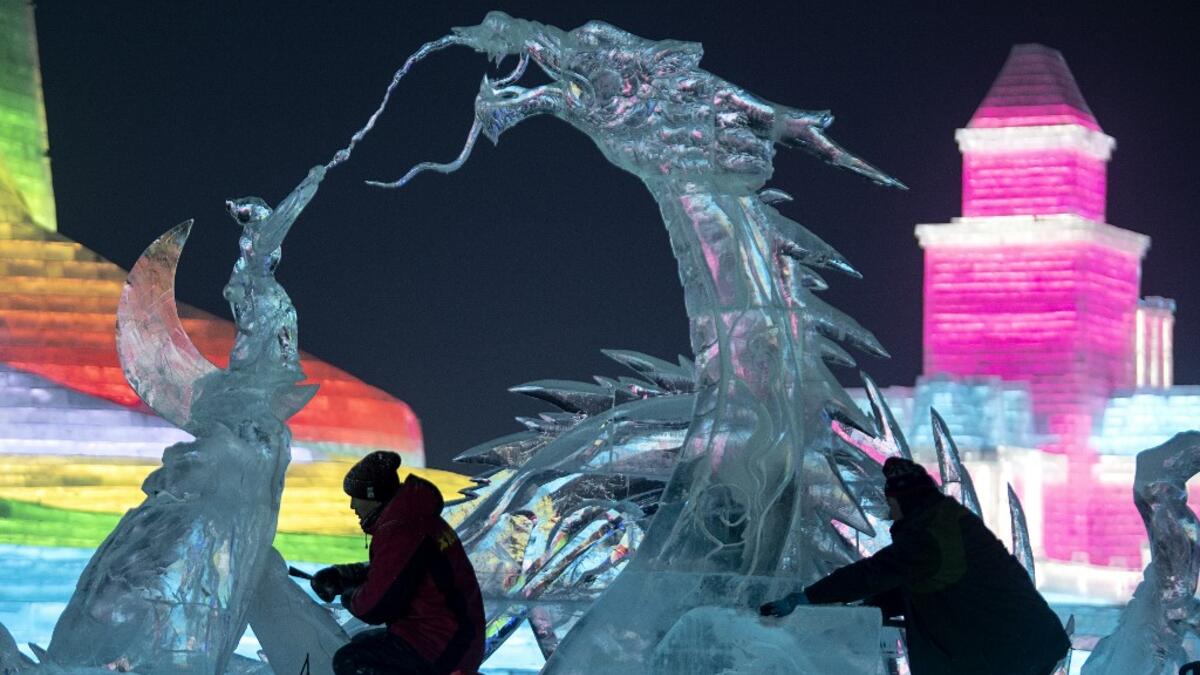 Ice sculptors give finishing touches on an ice sculpture ahead of the opening of the Harbin International Ice and Snow Festival in Harbin, in China's northeast Heilongjiang province on January 3, 2020. NOEL CELIS / AFP