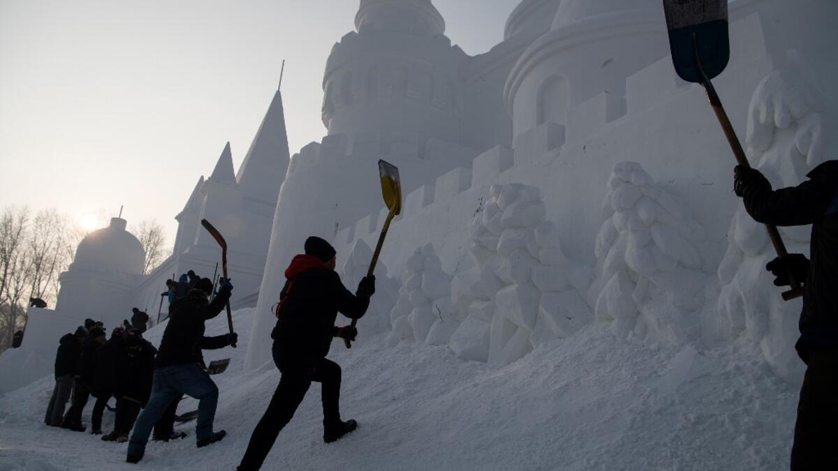 Workers apply the finishing touches to an ice sculpture ahead of the opening of the Harbin International Ice and Snow Festival in Harbin, in China's northeast Heilongjiang province on January 4, 2020. NOEL CELIS / AFP