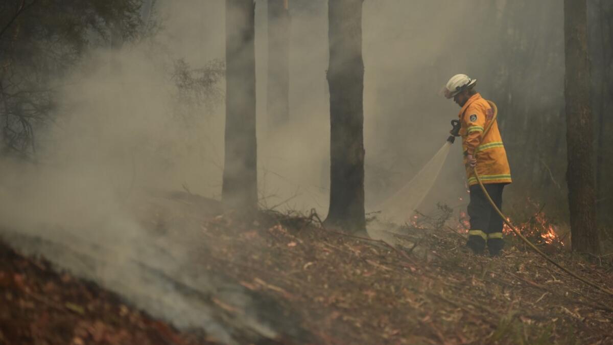 A firefighter tackles a bushfire south of Nowra on January 5, 2020. Australians on January 5 counted the cost from a day of catastrophic bushfires that caused "extensive damage" across swathes of the country and took the death toll from the long-running crisis to 24. PETER PARKS / AFP