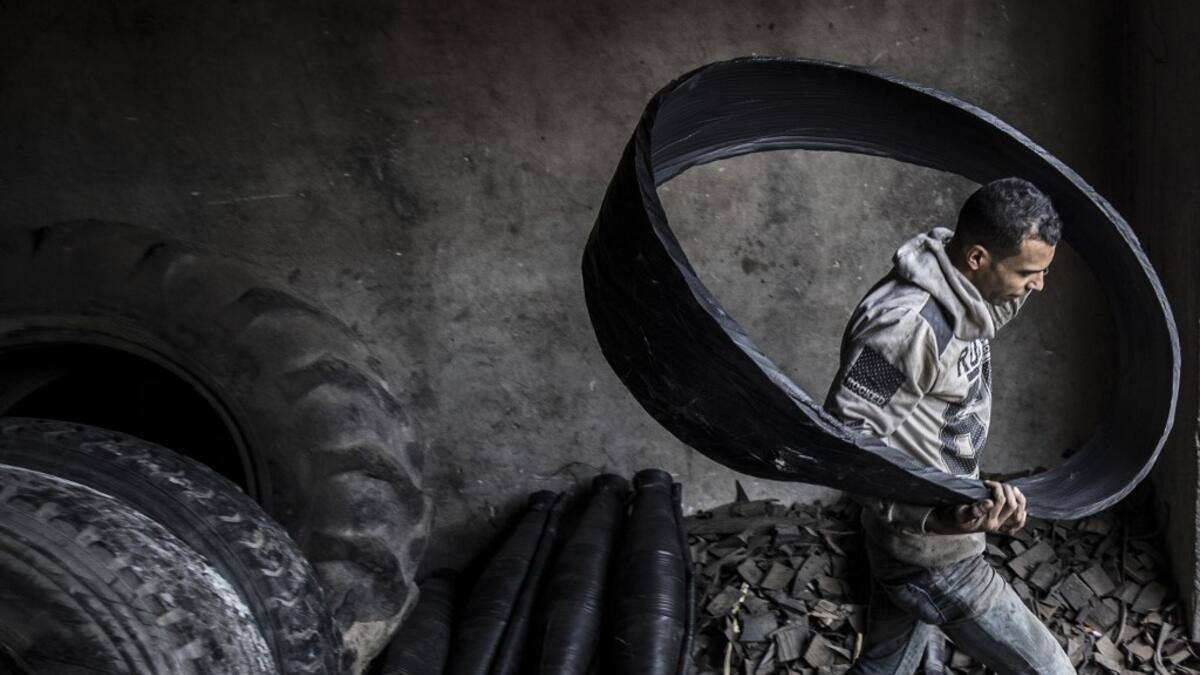 A labourer carries a ripped-out tyre liner at a rubber recycling workshop in the village of Mit al-Harun in Egypt's central Nile delta Gharbia Governorate, about 70 kilometres (43 miles) north of the capital, on January 14, 2020. Khaled DESOUKI / AFP