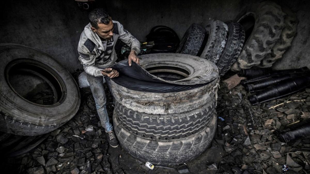 Residents of Mit al-Harun have for decades eked out a living by recycling old tyres into new rubber-based products. From early morning, workers covered in soot and dust can be seen sharpening their knives to cut the huge tyres stockpiled on the village's roadsides. Khaled DESOUKI / AFP