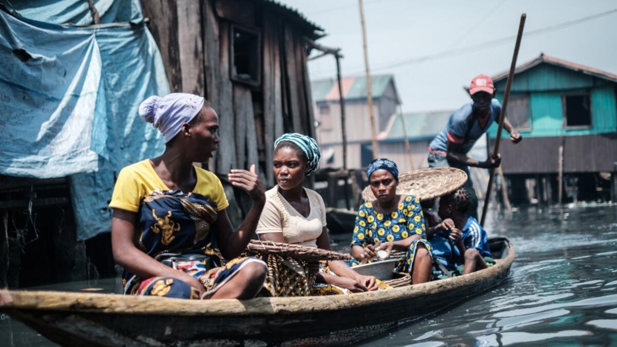 A picture taken on March 1, 2019 shows women on a boat in the Makoko waterfront community in a polluted lagoon in Lagos, Africa’s biggest megalopolis in Nigeria. The sprawling community began in the 19th century as a fishing village for immigrants who settled on the water's edge. As more arrived and land became rare, people started to move out onto the water. Over time, Makoko became a floating realm of perhaps a quarter of a million people, although the real number is anyone's guess. YASUYOSHI CHIBA / AFP
