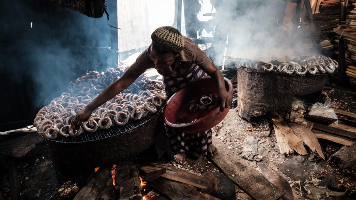 A picture taken on March 1, 2019 shows a woman smoking fish in the Makoko waterfront community in a polluted lagoon in Lagos, Africa’s biggest megalopolis in Nigeria. The sprawling community began in the 19th century as a fishing village for immigrants who settled on the water's edge. As more arrived and land became rare, people started to move out onto the water. Over time, Makoko became a floating realm of perhaps a quarter of a million people, although the real number is anyone's guess. YASUYOSHI CHIBA /