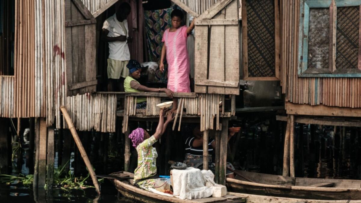 A picture taken on March 2, 2019 shows a woman selling breakfast from a boat in the Makoko waterfront community in a polluted lagoon in Lagos, Africa’s biggest megalopolis in Nigeria. The sprawling community began in the 19th century as a fishing village for immigrants who settled on the water's edge. As more arrived and land became rare, people started to move out onto the water. Over time, Makoko became a floating realm of perhaps a quarter of a million people, although the real number is anyone's guess.
