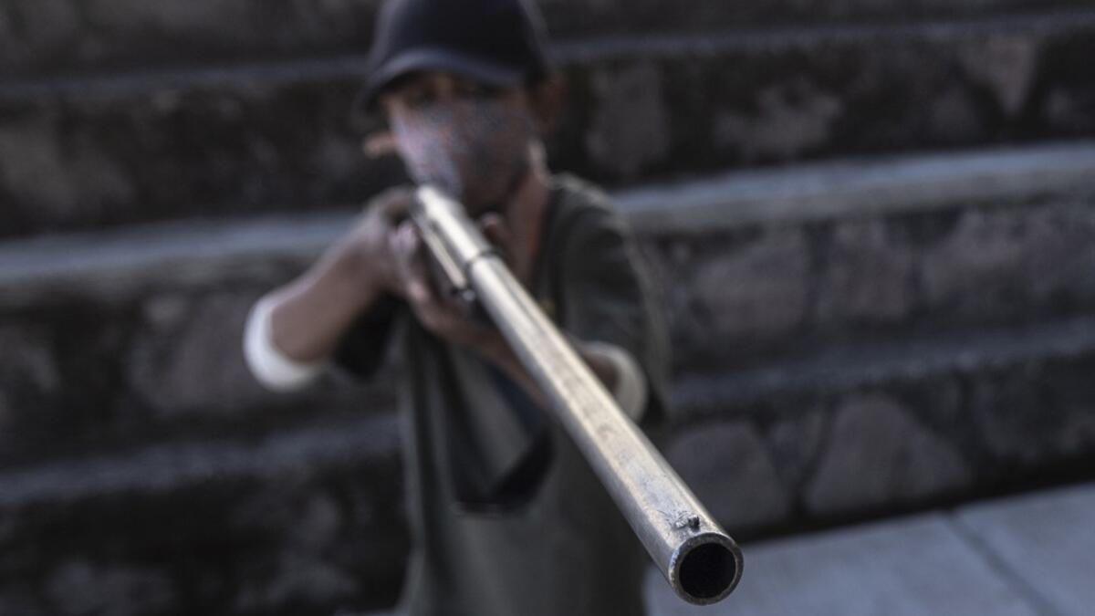 A boy aims a rifle as the Regional Coordinator of Community Authorities (CRAC-PF) community police force teaches a group of children how to use weapons, at a basketball court in the village of Ayahualtempan, Guerrero State, Mexico, on January 24, 2020. The CRAC-PF vigilante group trains children as young as five so they can protect themselves from drug-related criminal groups operating in the area. Pedro PARDO / AFP