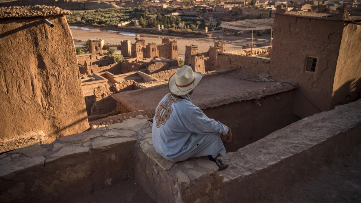 A man sits atop the Kasbah (ancient fortress) of Ait-Ben-Haddou, where scenes depicting the fictional city of Yunkai from the hit HBO television series "Game of Thrones" were filmed, about 32 kilometres northwest of the city of Ouarzazate south of Morocco's High Atlas mountains on January 27, 2020. FADEL SENNA / AFP