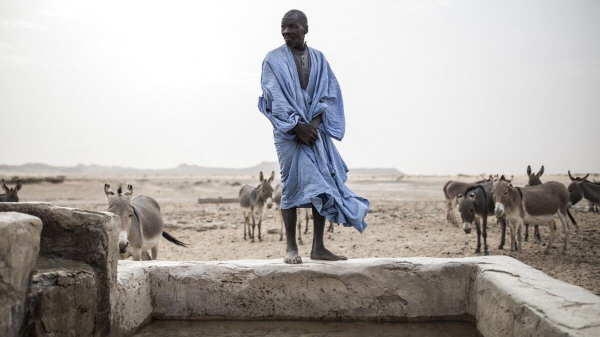 A man is seen at one of the few water wells along the caravan route from Tichitt to Aratane in Mauritania on January 25, 2020. In the arid West African country of Mauritania, the way of life of the traditional group of hunters known as the Nemadi is slowly disappearing. JOHN WESSELS / AFP