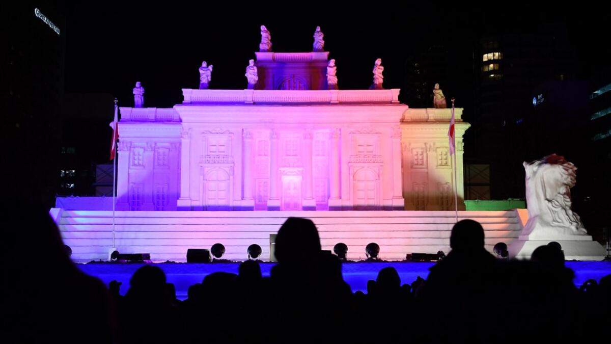 A giant snow sculpture supported by Hokkaido Broadcasting representing the Palace on the Isle in Warsaw, is seen after sundown during the Sapporo Snow Festival in Sapporo on February 4, 2020.  CHARLY TRIBALLEAU / AFP