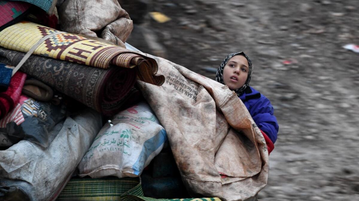 A Syrian girl rides in the back of a truck with belongings and furniture as people displaced from the south of Idlib province travelling in vehicles loaded with furniture and other belongings and fleeing from advancing government forces arrive at a camp for the internally displaced near Dayr Ballut, near the Turkish border in the rebel-held part of Aleppo province in the country's northwest on February 4, 2020. Rami al SAYED / AFP