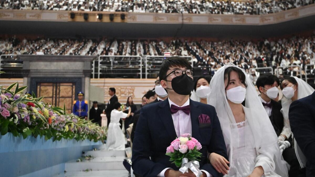 Couples wearing protective face masks attend a mass wedding ceremony organised by the Unification Church at Cheongshim Peace World Center in Gapyeong on February 7, 2020. South Korea has confirmed 24 cases of the SARS-like virus so far and placed nearly 260 people in quarantine for detailed checks amid growing public alarm. Jung Yeon-je / AFP