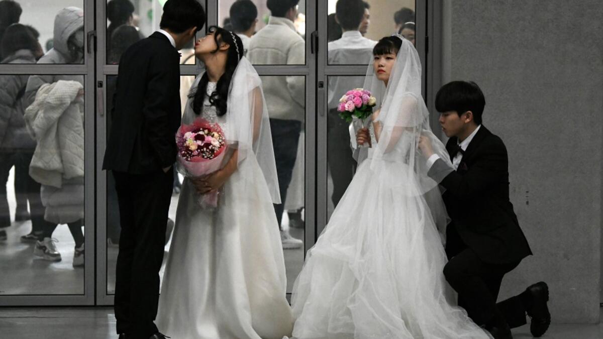 Couples prepare for a mass wedding ceremony organised by the Unification Church at Cheongshim Peace World Center in Gapyeong on February 7, 2020. Thousands of Unification Church couples married at a mass wedding to mark the eighth anniversary of the death of founder and self-proclaimed messiah Sun Myung Moon. Jung Yeon-je / AFP