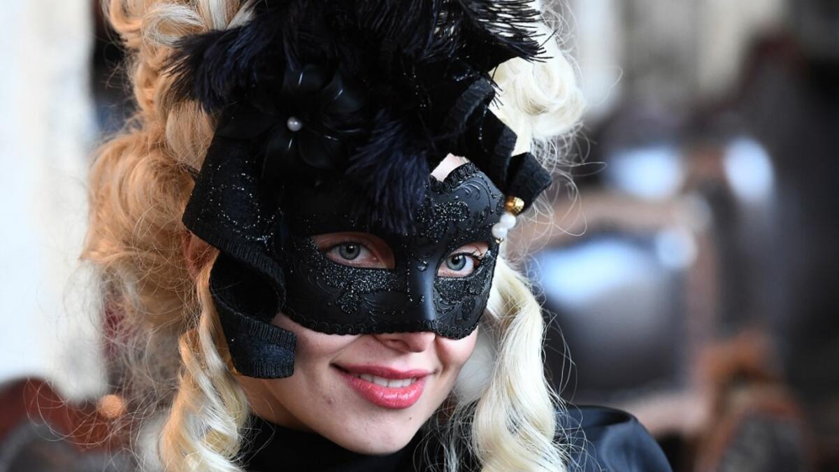 Masked reveller poses St Mark Square during the opening of the Venice Carnival on February 09, 2020. The carnival in Venice takes place until February 25, 2020. Vincenzo PINTO / AFP