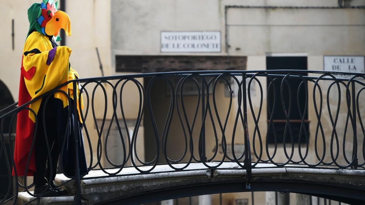 Masked revellers cross a bridge during the opening of the Venice Carnival on February 09, 2020. The carnival in Venice takes place until February 25, 2020. Vincenzo PINTO / AFP