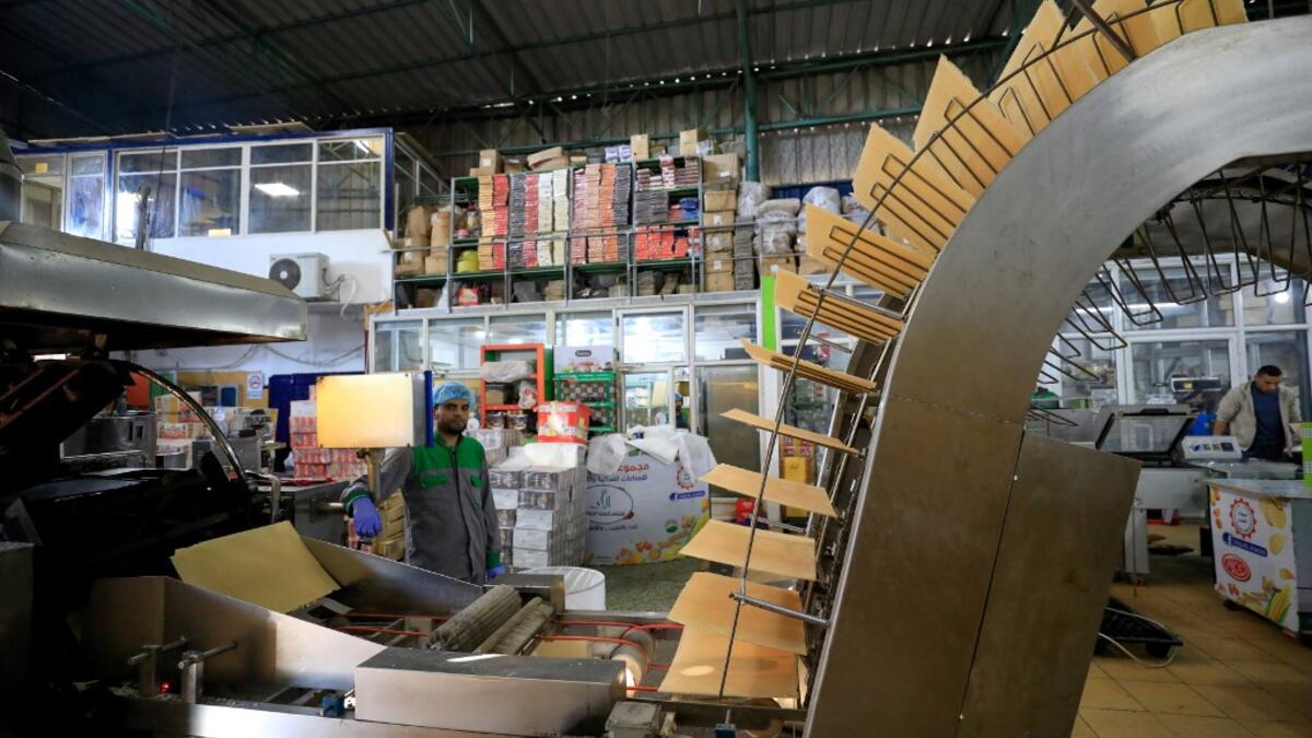 A worker monitors the production of wafers at al-Arees sweets factory in Gaza City on February 5, 2020. Al-Arees's products are Gazan but their components are not, as few of the basic raw ingredients are produced in the impoverished Mediterranean coastal strip.EMMANUEL DUNAND / AFP