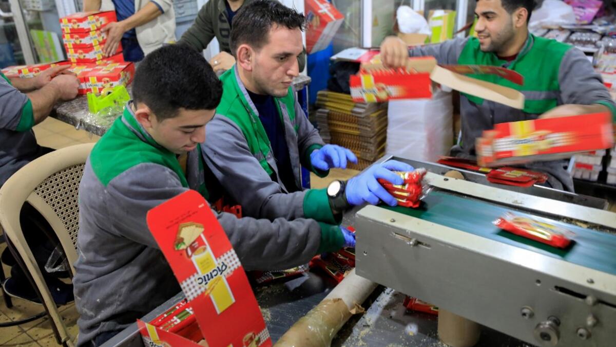 Workers pack chocolate bars at al-Arees factory in Gaza City on February 5, 2020. Al-Arees's products are Gazan but their components are not, as few of the basic raw ingredients are produced in the impoverished Mediterranean coastal strip. Israel controls all goods that enter Gaza, imposing a blockade that tightened after the tiny enclave was seized by the Islamist group Hamas in 2007. EMMANUEL DUNAND / AFP