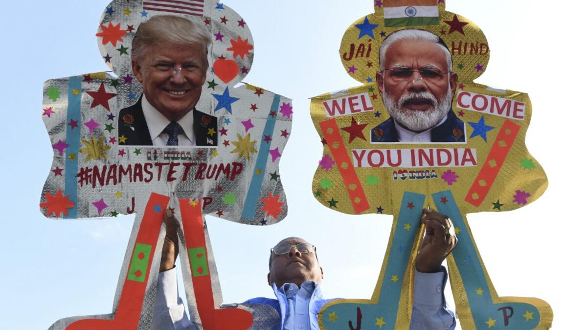 Kite-maker Jagmohan Kanojia (C) poses with kites decorated with the pictures of US President Donald Trump (R) and India's Prime Minister Narendra Modi, in Amritsar on February 23, 2020, ahead of Trump's visit to India. Trump makes his first official visit to India on February 24. NARINDER NANU / AFP